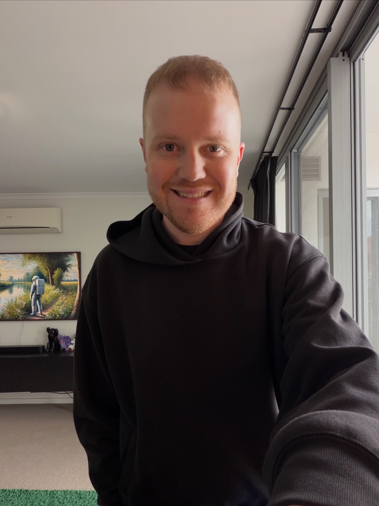 Matt smiling beside a window in a black hoodie, 26 September 2026.